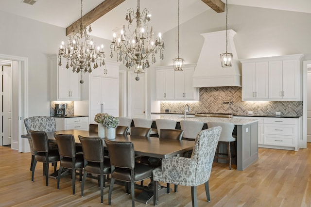 dining space with light wood finished floors, visible vents, high vaulted ceiling, and beam ceiling