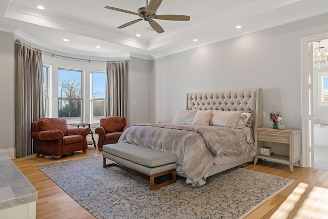 bedroom with light wood finished floors, recessed lighting, a raised ceiling, ornamental molding, and ceiling fan with notable chandelier