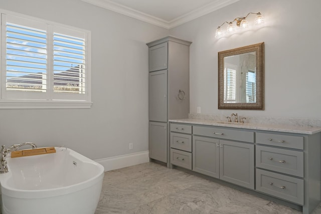 full bath featuring a freestanding tub, crown molding, vanity, and baseboards