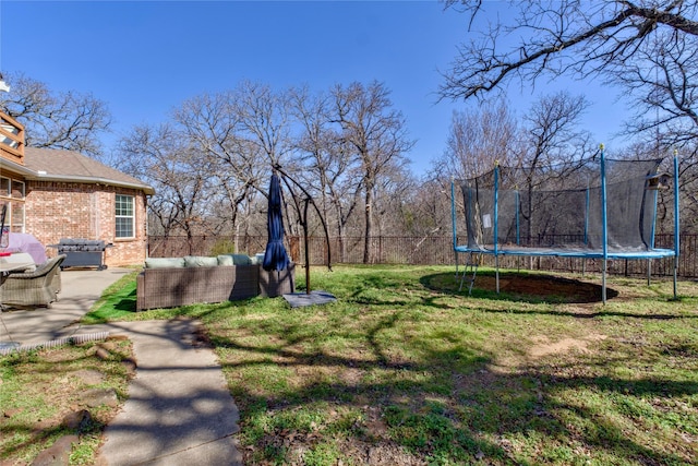 view of yard with a trampoline, a patio area, outdoor lounge area, and fence