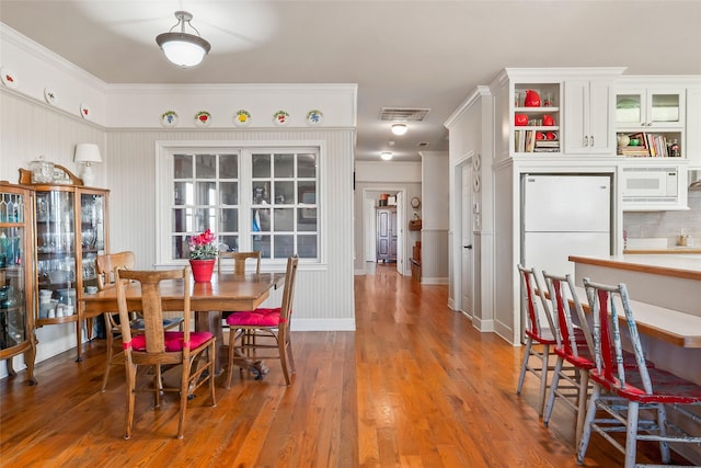 dining space with wood finished floors and visible vents