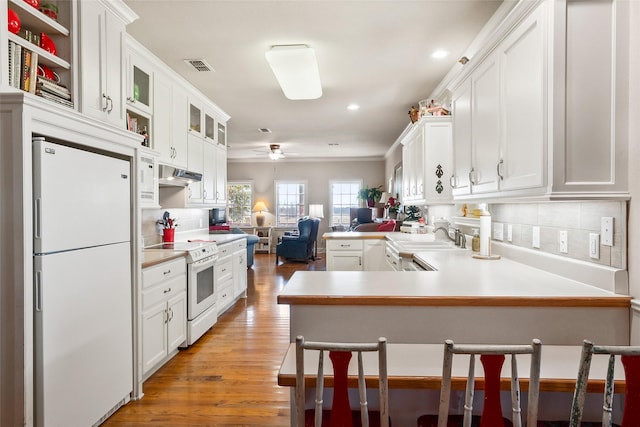 kitchen featuring white appliances, visible vents, a ceiling fan, under cabinet range hood, and a sink