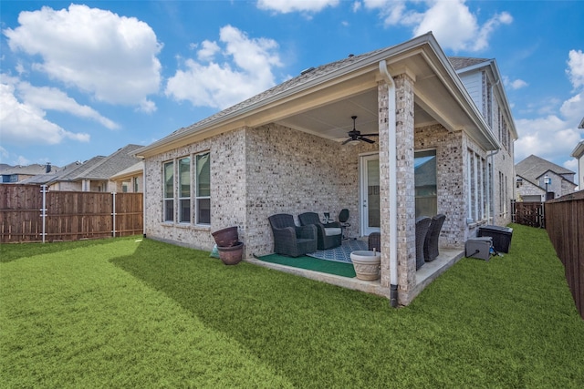 back of house with a lawn, a fenced backyard, ceiling fan, a patio area, and brick siding