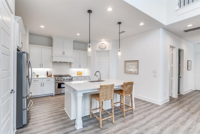 kitchen with white cabinetry, appliances with stainless steel finishes, light countertops, and a sink