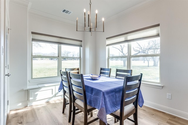 dining space featuring ornamental molding, light wood-style flooring, visible vents, and baseboards