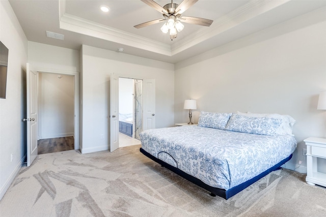 bedroom with light carpet, visible vents, a tray ceiling, and ornamental molding