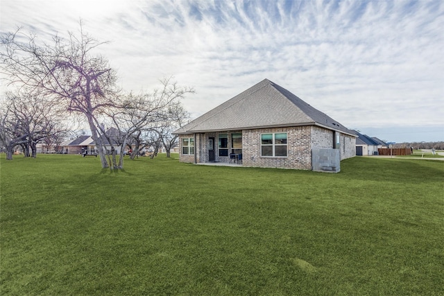 648 Half Moon Way, Runaway Bay, TX 76426 - rear view of house featuring a lawn, brick siding, and a shingled roof
