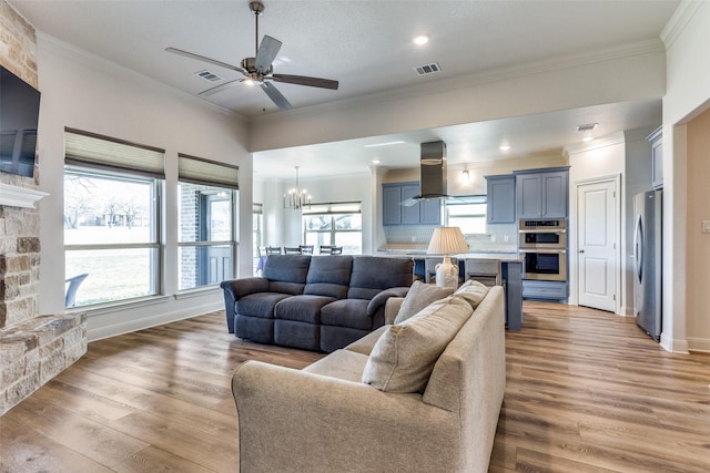 648 Half Moon Way, Runaway Bay, TX 76426 - living room featuring light wood-type flooring, ornamental molding, ceiling fan, a chandelier, and baseboards