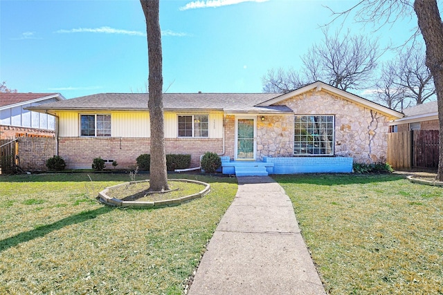 ranch-style home featuring a front yard, brick siding, fence, and roof with shingles