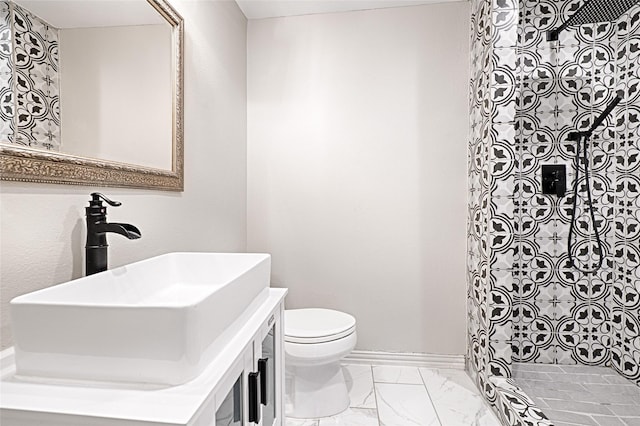 full bathroom featuring baseboards, toilet, marble finish floor, a tile shower, and vanity