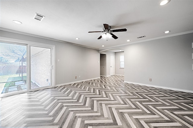 unfurnished room with visible vents, arched walkways, a ceiling fan, baseboards, and crown molding