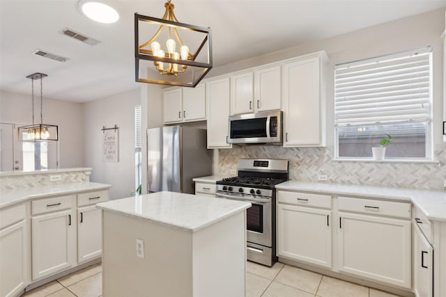 kitchen with a chandelier, appliances with stainless steel finishes, backsplash, and visible vents