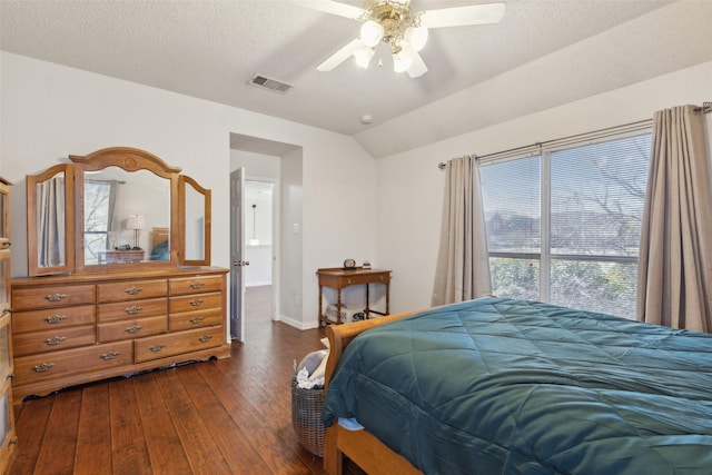 bedroom featuring baseboards, visible vents, lofted ceiling, dark wood-type flooring, and a textured ceiling