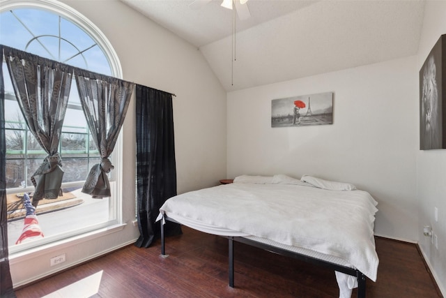 bedroom with ceiling fan, vaulted ceiling, and wood finished floors