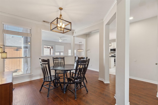 dining room with crown molding, baseboards, and wood finished floors