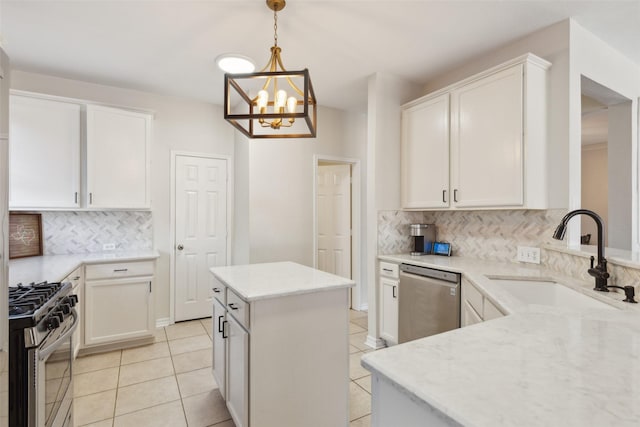 kitchen with stainless steel appliances, white cabinetry, a sink, and light tile patterned floors