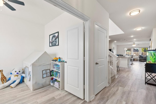 rec room featuring ceiling fan and light wood finished floors