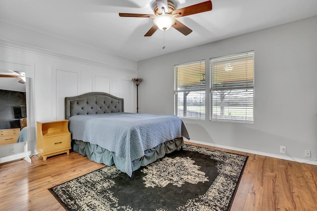 bedroom featuring wood-type flooring, baseboards, and ceiling fan