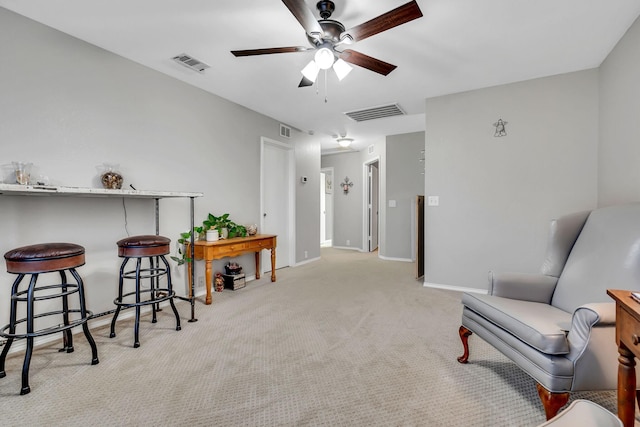 living area featuring carpet, visible vents, ceiling fan, and baseboards