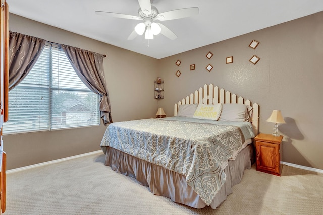 bedroom featuring a ceiling fan, light colored carpet, and baseboards