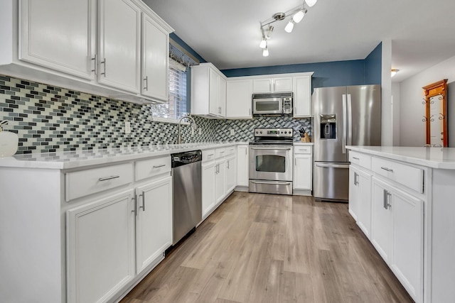 kitchen featuring appliances with stainless steel finishes, white cabinets, light countertops, and light wood-style floors