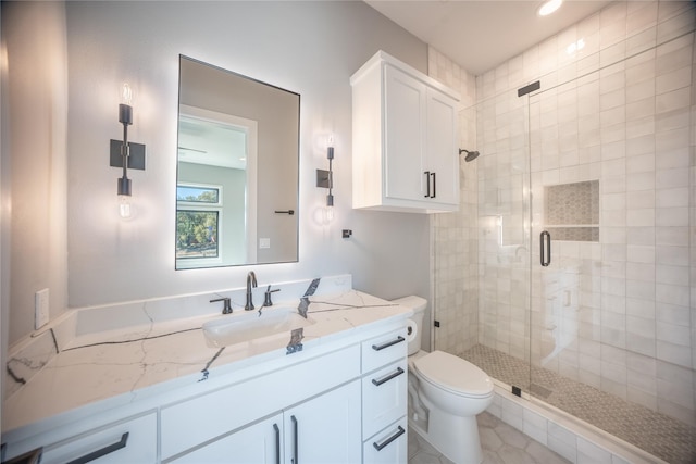 bathroom featuring a shower stall, toilet, and vanity