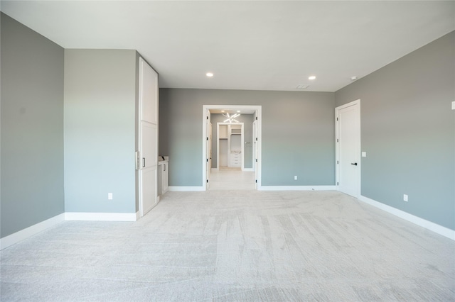 unfurnished bedroom with light carpet, baseboards, and recessed lighting