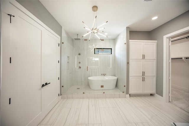 bathroom with recessed lighting, a closet, a soaking tub, a shower stall, and a chandelier