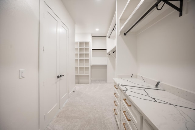 walk in closet featuring light colored carpet