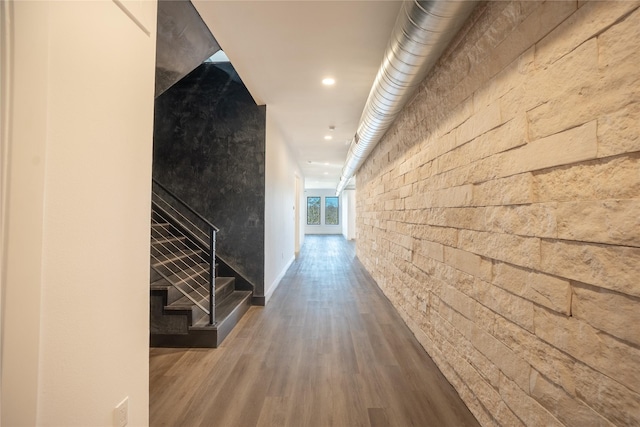 corridor with stairs, wood finished floors, and recessed lighting