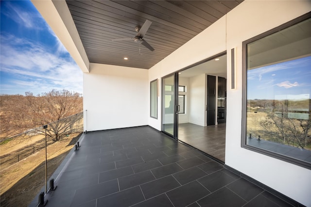 view of patio with a ceiling fan and a balcony