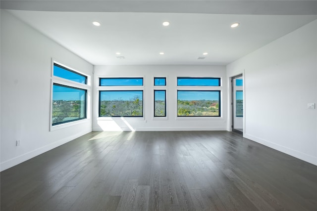 unfurnished room with visible vents, baseboards, dark wood-type flooring, and recessed lighting