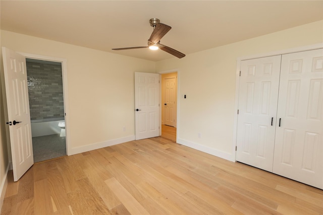 unfurnished bedroom with ceiling fan, light wood-style flooring, baseboards, a closet, and ensuite bath