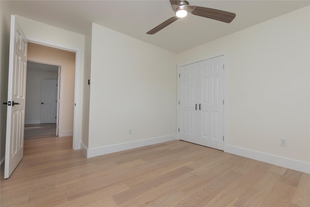 unfurnished bedroom with a closet, baseboards, and light wood finished floors