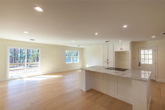 kitchen featuring light stone counters, recessed lighting, white cabinetry, and light wood-style floors