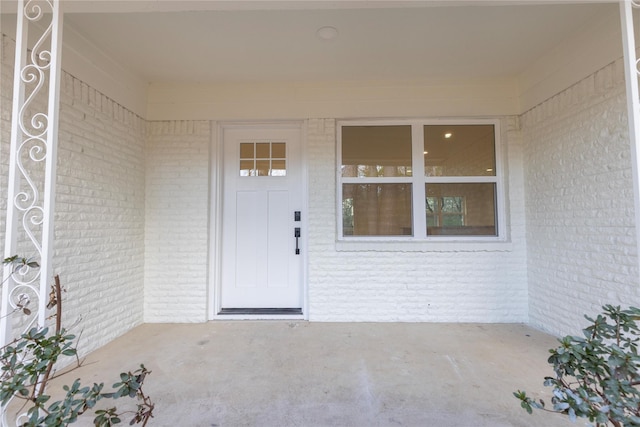 entrance to property featuring brick siding