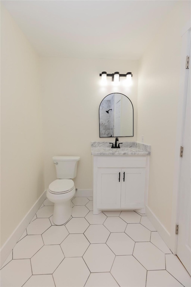 bathroom featuring baseboards, vanity, and toilet