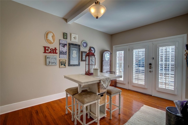 dining area with plenty of natural light, beamed ceiling, and light wood finished floors