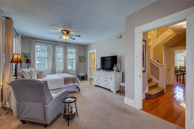 bedroom with light carpet, multiple windows, visible vents, and baseboards