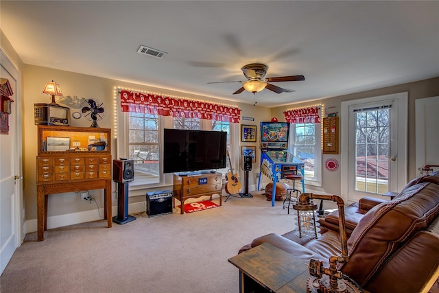 carpeted living area featuring baseboards, visible vents, and a ceiling fan