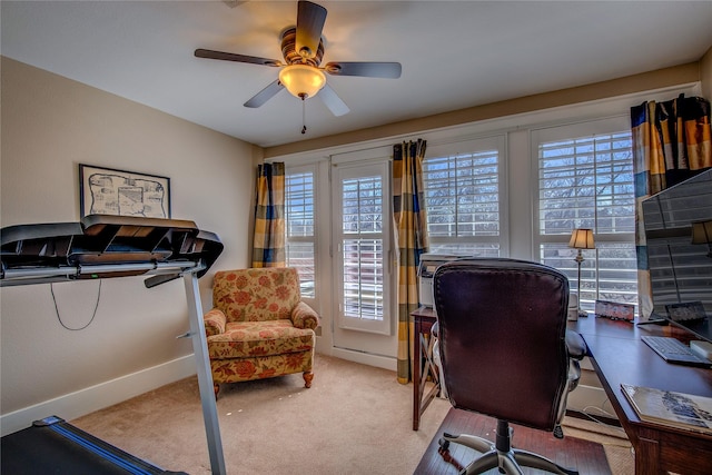 carpeted office space with baseboards, a ceiling fan, and a healthy amount of sunlight