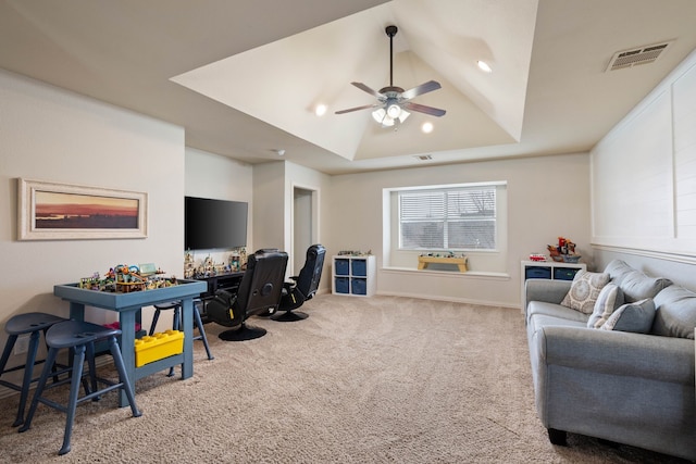 office space featuring visible vents, a ceiling fan, lofted ceiling, a tray ceiling, and carpet flooring