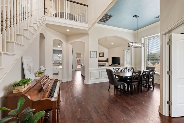 dining area with ornamental molding, dark wood-style flooring, visible vents, and an inviting chandelier