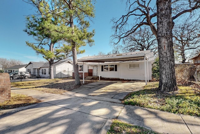 view of front of property with concrete driveway and fence