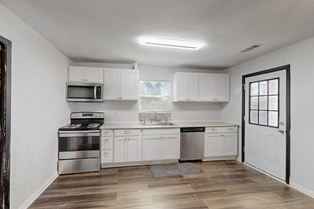 kitchen featuring white cabinetry, visible vents, stainless steel appliances, and a sink