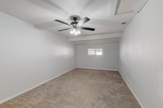 carpeted empty room featuring baseboards, visible vents, vaulted ceiling, and a textured ceiling