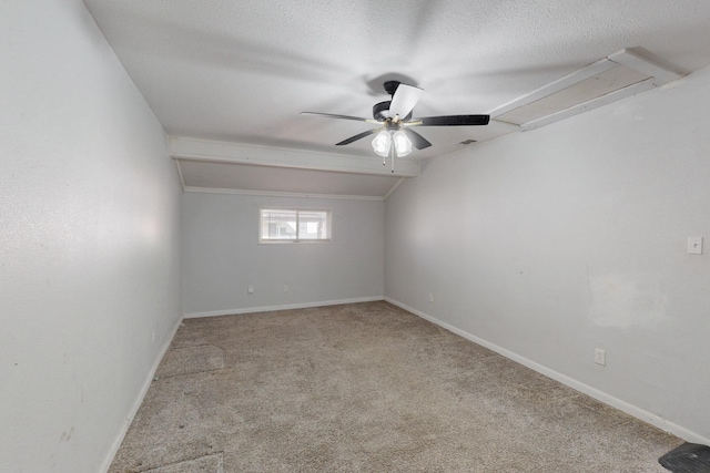 empty room with baseboards, lofted ceiling, ceiling fan, a textured ceiling, and carpet floors