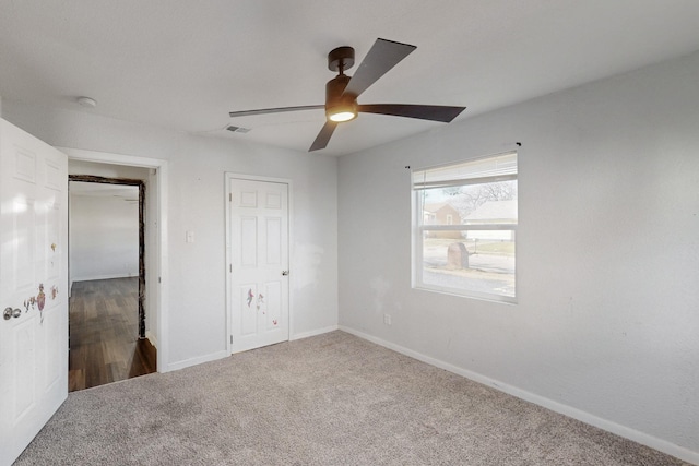 unfurnished bedroom featuring a ceiling fan, carpet flooring, visible vents, and baseboards