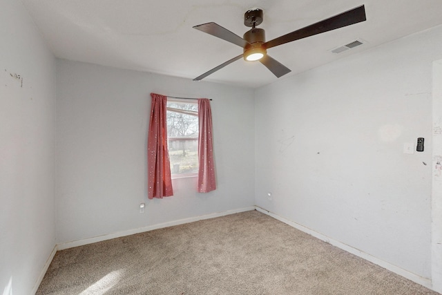 carpeted spare room with ceiling fan, visible vents, and baseboards