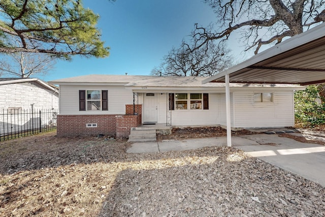 view of front of home with a carport, brick siding, fence, and driveway